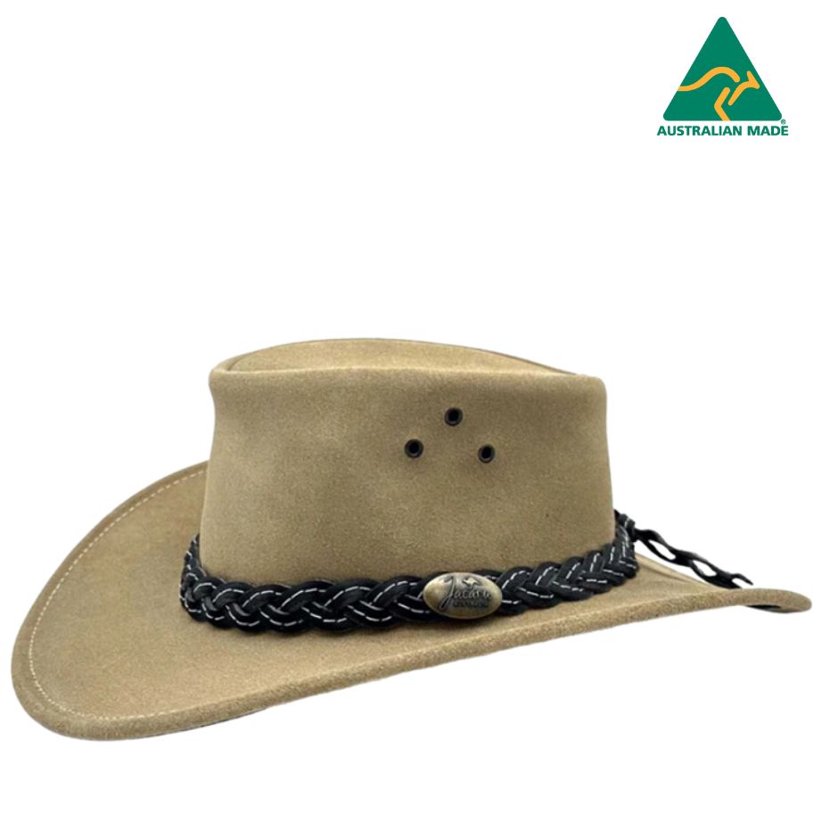 A beige colored Jacaru 1007 Wallaroo Suede hat with a black braided band and metal emblem, handcrafted from brushed cow suede.